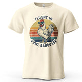 Beige t-shirt with a rooster graphic and text 'Fluent in Fowl Language' on a white background